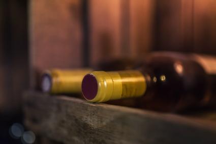 Dos botellas de vino tinto en estante de madera