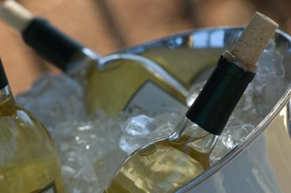 Botellas de vino blanco enfriándose en una tina de hielo